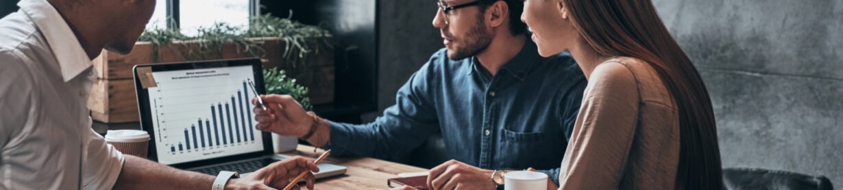 Business professionals. Group of young confident business people analyzing data using computer while spending time in the office